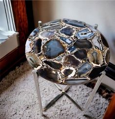 a table that is sitting on some kind of metal stand in front of a window