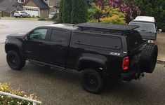 a black pick up truck parked in front of a house