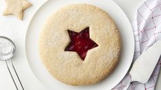 a white plate topped with a cookie covered in icing next to a star shaped cookie