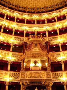 the inside of a theatre with chandeliers and curtains