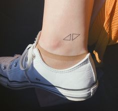 a woman's foot with a small triangle tattoo on her left side ribcage