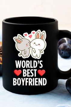 a black coffee mug with the words world's best boyfriend and two rabbits on it