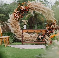 a wooden bench sitting in the middle of a lush green field next to a flower filled archway