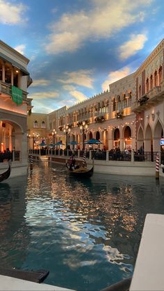 the inside of a shopping mall with gondolas and boats in the water at dusk