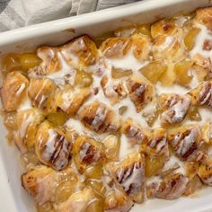 a casserole dish filled with cinnamon rolls covered in icing