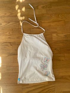 a women's white tank top with butterfly applique on the front and back