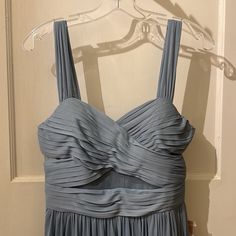 a dress hanging on a hanger in front of a door