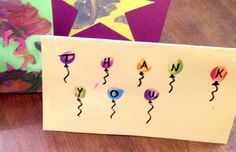 a handmade thank you card with balloons and stars on it next to a greeting card