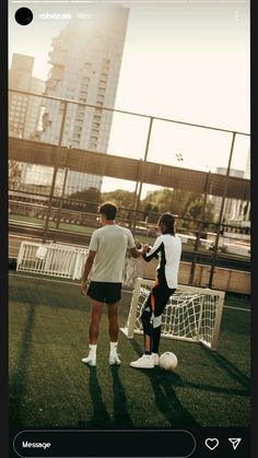 two men shaking hands in front of a soccer goal with the city skyline behind them