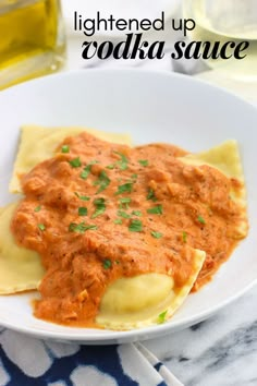 a white plate topped with ravioli covered in sauce