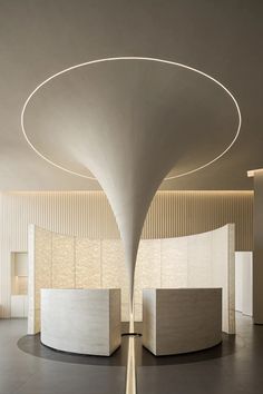 the interior of an office building with white walls and circular lighting fixture on the ceiling