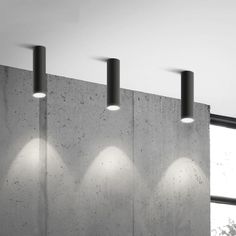 four lights are hanging from the concrete wall