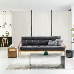 a living room with a couch, coffee table and stools in it's center