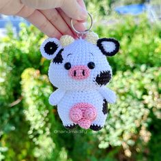 a crocheted pig keychain is being held by someone's hand