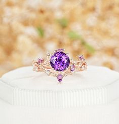 an amethoraite and diamond ring sitting on top of a white box