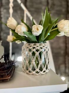 white tulips in a glass vase on a table