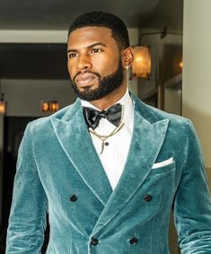 a man in a blue velvet jacket and bow tie