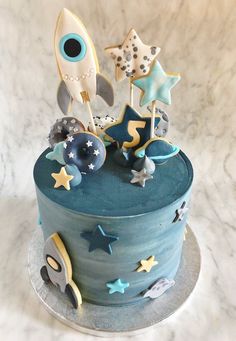 a blue cake with stars and rockets on top