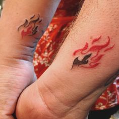 two people holding hands with tattoos on their arms and one has a bird on it