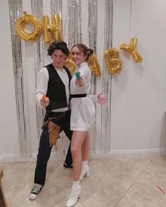 a man and woman posing for a photo in front of balloons that spell out i love you