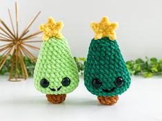 two crocheted green and yellow items sitting next to each other on a white surface