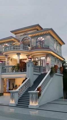 a large white house with lots of windows and balconies on the second floor