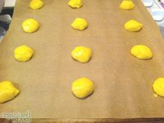 doughnuts on a baking sheet ready to go into the oven with yellow icing