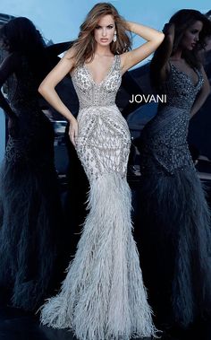 Jovani 02798 Feather Bottom Embellished Fitted Evening Dress Style Code: 02798 Available Colors: silver Silver and multicolor beaded evening dress with a sleeveless fitted sheer bodice, v-neckline and low v-shaped back with hidden zipper. Floor-length form-fitting skirt with a feather trim mermaid shape end. Prom Dresses With Feathers, Dresses With Feathers, Jovani Prom Dresses, Wedding Glamour, Glam Dress, Matric Dance, Beaded Mermaid, Shower Dress, Jovani Prom