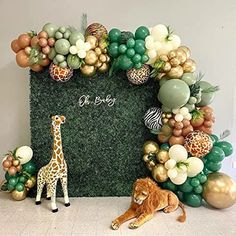 a giraffe and a lion are sitting in front of a fake grass wall