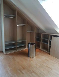 an empty room with shelves and a trash can