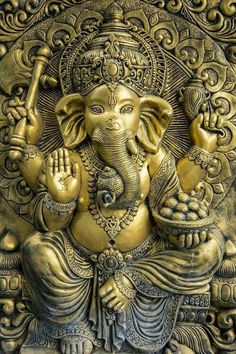 an intricately carved gold ganesha with his hands in the air and eyes closed