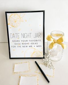 a glass jar with a yellow ribbon next to some cards and a pen on a table