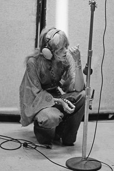 a woman sitting in front of a microphone with headphones on