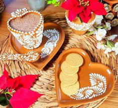 two heart shaped plates with cookies on them and poinsettis in the background