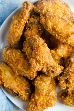 fried chicken on a white plate with a blue towel