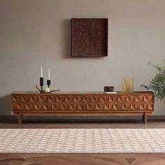 a living room scene with focus on the sideboard and plant in the centerpiece