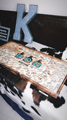 a large wooden table with writing on it in front of a k sign and other items