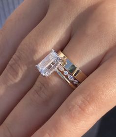 a close up of a person's hand with a ring on their finger and an emerald stone in the middle