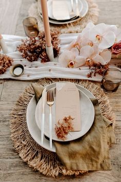 the table is set with white plates and silverware