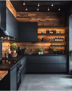 a modern kitchen with black cabinets and wood paneling on the wall, along with potted plants