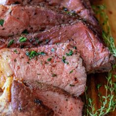 sliced steak on a cutting board with herbs