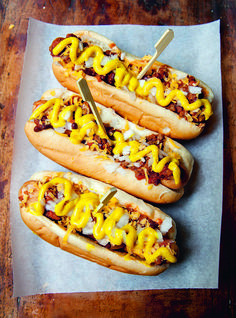 two chili dogs on a plate with cheese