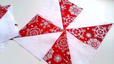 three red and white snowflakes are on the table next to each other