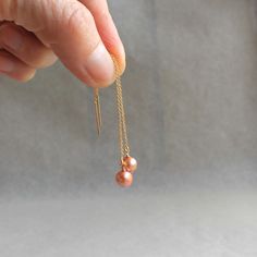 "Subtle and soft pink pearls dangle from delicate gold-filled threader ear wires.  Warm and golden. 3\" total length but can be adjusted ." Adjustable Gold Pearl Earrings With Ear Wire, Gold Pearl Earrings With Dangling Beads As Gift, Rose Gold Dangling Beads Earrings As Gift, Rose Gold Dangling Beads Earrings For Gift, Rose Gold Earrings With Dangling Beads For Gift, Delicate Pearl Earrings With Dangling Beads Gift, Delicate Adjustable Gold Threader Earrings, Gold Linear Earrings With Pearl Charm As Gift, Rose Gold Jewelry With Dangling Beads For Gift