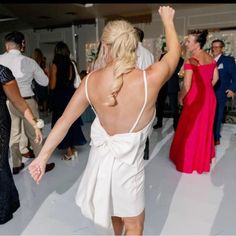 the back of a woman's dress as she dances with other people at a party