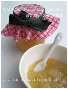 two jars filled with honey sit next to each other on a white tablecloth covered surface