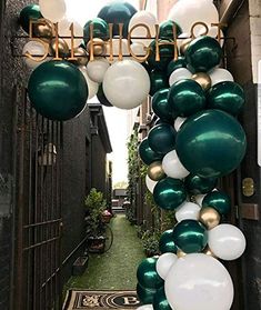 an entrance to a building decorated with green and white balloons