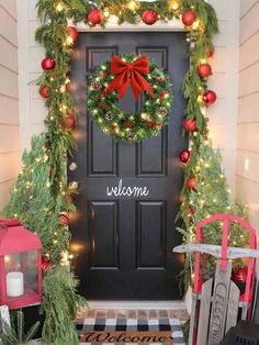 a front door decorated with christmas wreaths and lights