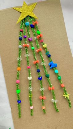 a christmas tree made out of beads and other items on a piece of brown paper