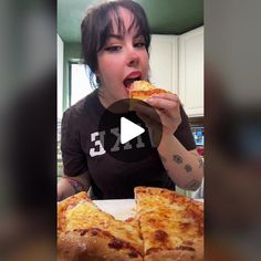 a woman eating a slice of pizza in front of her face and looking at the camera